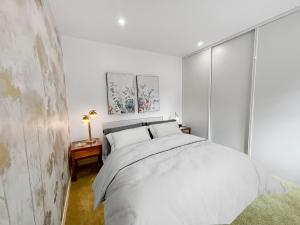 a white bedroom with a large bed in it at Climatisation, Parking privé, Maison plein pied proche gare, 1 chambre, capacité 4 in Brétigny-sur-Orge