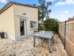 a patio with a table and a fence at Climatisation, Parking privé, Maison plein pied proche gare, 1 chambre, capacité 4 in Brétigny-sur-Orge