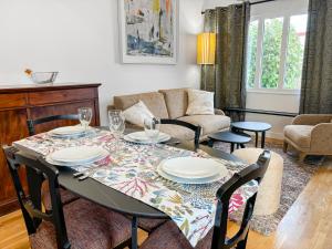 a living room with a table with chairs and a couch at Climatisation, Parking privé, Maison plein pied proche gare, 1 chambre, capacité 4 in Brétigny-sur-Orge