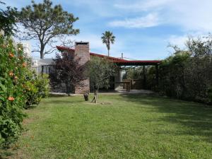 a garden with a brick house with a tree at Las Olas in Piriápolis