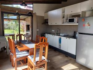 a kitchen with a table and chairs and a refrigerator at Las Olas in Piriápolis
