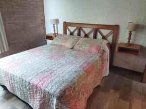 a bedroom with a bed and two night stands with lamps at Las Olas in Piriápolis