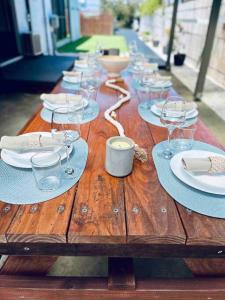 een houten tafel met borden en wijnglazen erop bij DOCK 08 Riverside Entertainer Pets Welcome in Chittaway Point +28 foto's