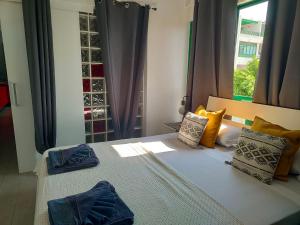sypialnia z łóżkiem z poduszkami i oknem w obiekcie Ailana Suite Vistas al Mar y con Piscina w Costa Teguise