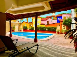 a patio with a chair and a swimming pool at Hotel Zihuatanejo Centro in Zihuatanejo