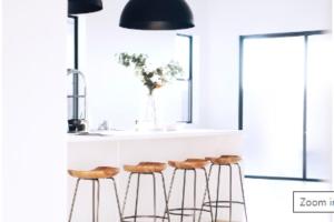 a kitchen with three bar stools under a black lamp at Letty's Happy Place in Midsayap