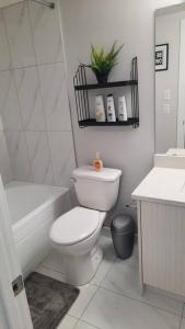 a bathroom with a toilet and a tub and a sink at Carsonway Basement Suite in Edmonton