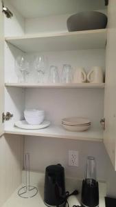 a kitchen shelf with plates and glasses and a blender at Carsonway Basement Suite in Edmonton +11 photos