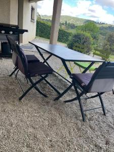 Una mesa de picnic y dos sillas en un patio. en Hébergement - Limonest, en Limonest 1 foto más
