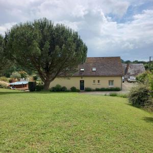 a house with a tree in the middle of a yard at 4 Chambres et dortoir 5x90 in Cérans-Foulletourte