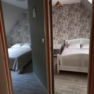 a bedroom with two beds and a wall paper at 4 Chambres et dortoir 5x90 in Cérans-Foulletourte
