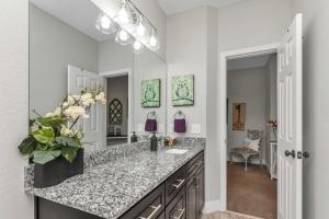 a bathroom with a sink and a vase of flowers on a counter at Owl's Nest - Cozy Townhome Close to Beaches, Attractions & More! in Fort Walton Beach +30 photos