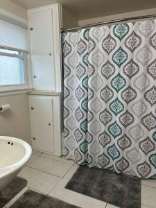 a bathroom with a shower curtain and a sink at Wilson Street Home in Little Chute +9 photos