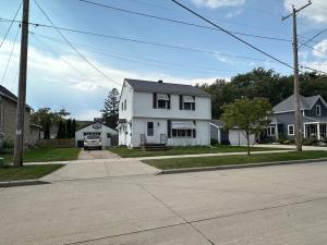 a white house on the side of a street at Wilson Street Home in Little Chute