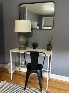a desk with a chair and a lamp and a mirror at Wilson Street Home in Little Chute