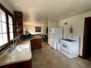 a kitchen with a sink and a white refrigerator at Wilson Street Home in Little Chute