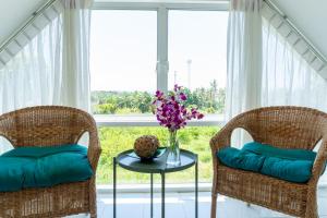 Phra Ae beachにあるLanna Lantaの窓の前に椅子2脚とテーブル1台