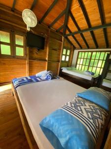 a bedroom with two beds in a wooden cabin at Ecohotel La Italia- Hotel Venecia, Antioquia in Venecia +42 photos