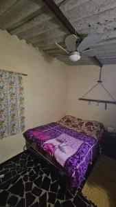 a bedroom with a purple bed and a ceiling fan at Ferme Benslimane 30 min de rabat in O Ben Slimane
