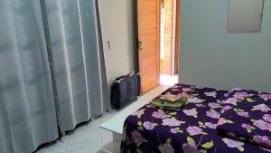 una camera da letto con un letto con un piumone viola di Linda casa Morada da Praia com piscina privativa e muito espaço pra você e seu pet a Bertioga Altre 20 foto