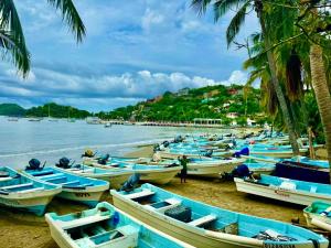 a group of boats sitting on the beach at Hotel Zihuatanejo Centro in Zihuatanejo