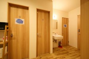 bagno con porta in legno e lavandino di Hiroei Hostel ad Osaka
