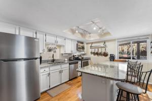 a kitchen with white cabinets and a stainless steel refrigerator at Creekside Condos #7 by Summit County Mountain Retreats in Frisco