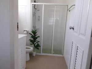 Un baño con ducha y WC y una planta. en Charlie's Angels Hotel Restaurant, en Rawai Beach
