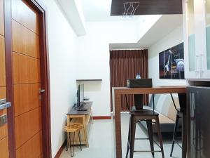 PampangにあるLuxury 2BR at Vida View Makassar Apartment By Travelioのデスク、テーブル、コンピュータが備わる客室です。