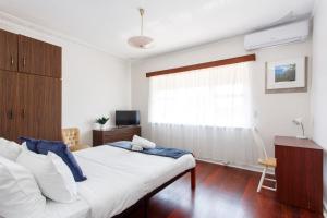 a white bedroom with a bed and a window at Villa Fiore in South Fremantle