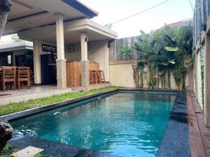 a swimming pool in front of a house at Pering Diamond Villa in Keramas