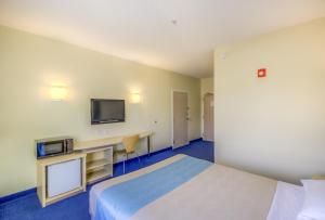 Cette chambre comprend un lit et une télévision. dans l'établissement Motel 6-Estevan, SK, à Estevan