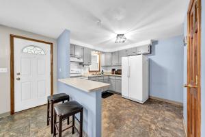 a kitchen with a white refrigerator and two stools at Cozy Duplex Near BUF International Airport in Cheektowaga