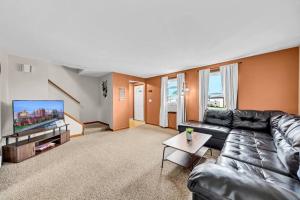 a living room with a couch and a tv at Cozy Duplex Near BUF International Airport in Cheektowaga