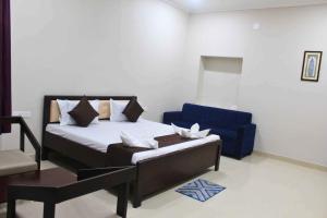 una camera da letto con un letto e una sedia blu di Hotel Yubraj a Puri
