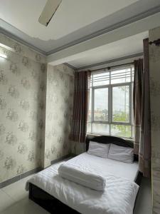 a bed in a room with a window and a bed sidx sidx sidx at Motel Thiên Phúc 1 in Can Tho