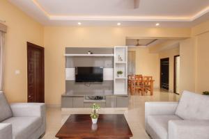 a living room with two couches and a tv at Classic Heights Serviced Apartments, near IIM Bangalore, in Bengaluru