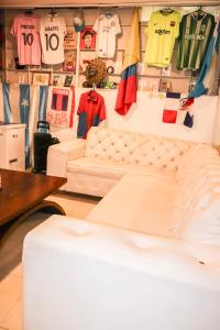 a room with a couch and shirts hanging on a wall at Nahimara Champeta Hostel in Cartagena de Indias
