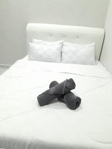 a stuffed animal is laying on a white bed at Dmana Homestay Arau Perlis in Arau