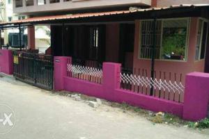 a pink fence in front of a building at Charisma Homestay in Mangalore