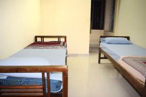 two beds are in a room withthritisthritisthritisthritisthritisthritisthritisthritisthritis at Charisma Homestay in Mangalore