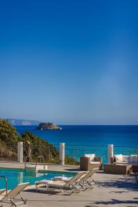 a pool with lounge chairs and a view of the ocean at Costa Avithos in Svoronata