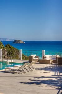 a group of lounge chairs next to a swimming pool at Costa Avithos in Svoronata