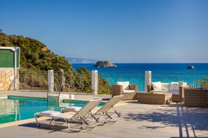 a patio with chairs and a pool and the ocean at Costa Avithos in Svoronata