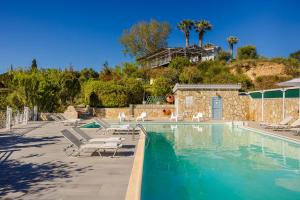 a swimming pool with lounge chairs and a house at Costa Avithos in Svoronata