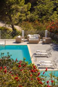 a swimming pool with chaises and chairs next to at Costa Avithos in Svoronata