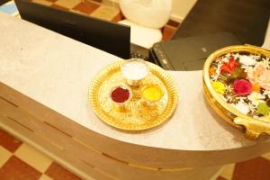 a table with a plate of food and a bowl of salad at Golden Dawn Residency in Tiruvannāmalai