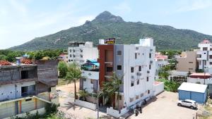 a city with buildings and a mountain in the background at Golden Dawn Residency in Tiruvannāmalai