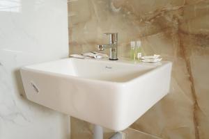 a white sink with a faucet in a bathroom at Golden Dawn Residency in Tiruvannāmalai +45 photos