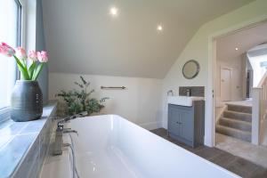 a bathroom with a large white tub and a sink at Griffin's Rest - Parking, Countryside views in Newquay